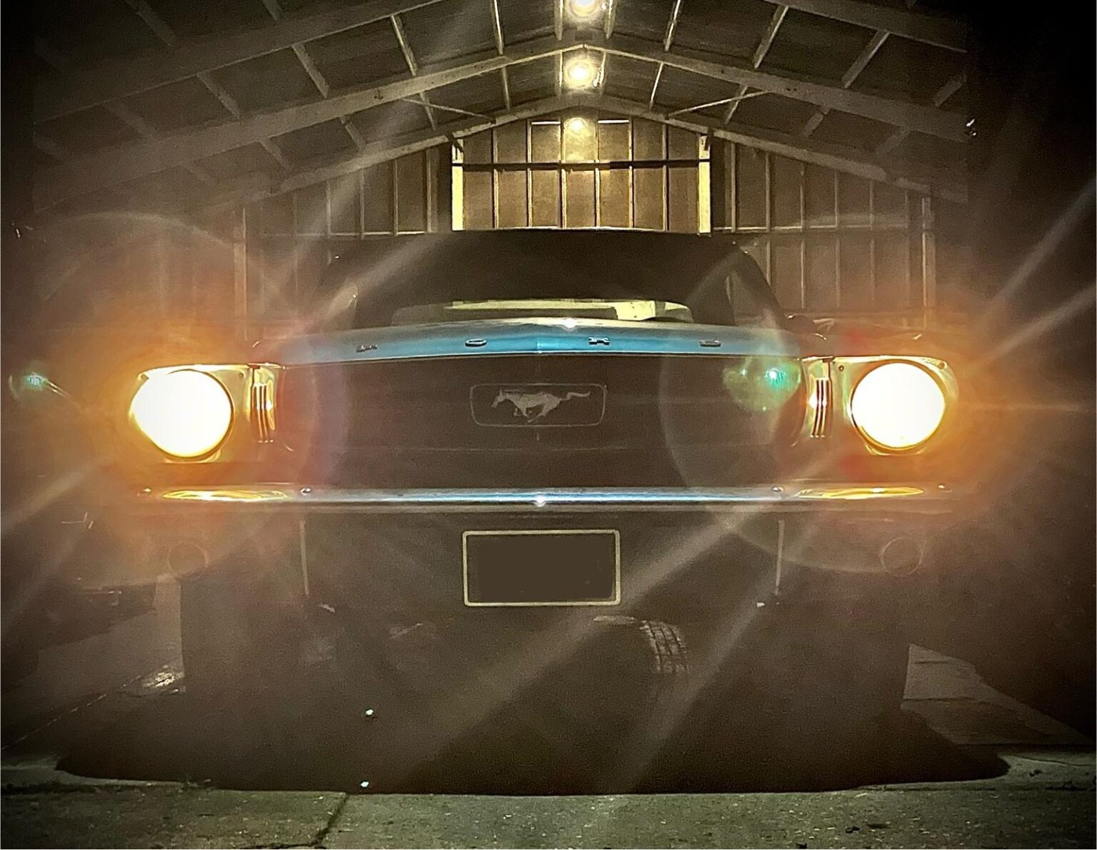 Classic Ford Mustang with its headlights on at the entrance to our vehicle storage unit in Kent